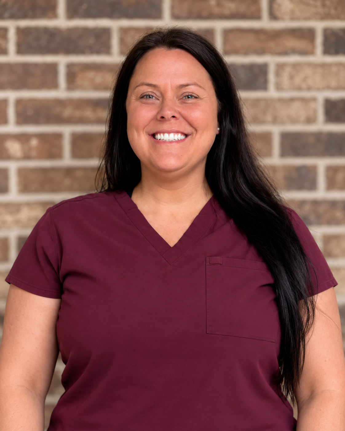 Dr. Brittany Scoggins smiling in burgundy scrubs